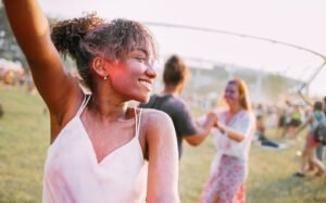 African American young woman with friends dancing at summer holi festival