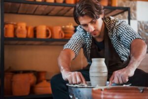 Detailing by special tool. Ceramist uses potter's wheel and creates a handmade clay product.