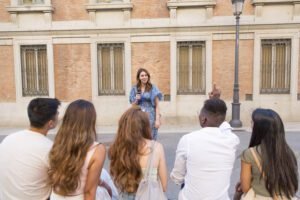 Man asking a question to a tour guide in front of a group of friends in a public square