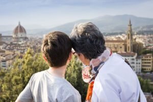 Senior woman and grandson looking out at cityscape, Florence, Italy
