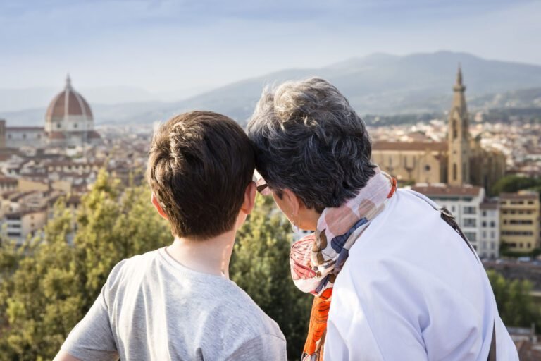 Senior woman and grandson looking out at cityscape, Florence, Italy