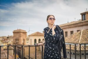 Stylish woman posing in the old part of the town against tile roofs. Medieval city of Toledo in the center of Spain