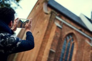 Taking in all the sights. Rearview shot of a young man taking photographs while on vacation